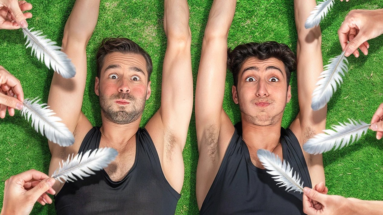 Two men being tickled with feathers on grass